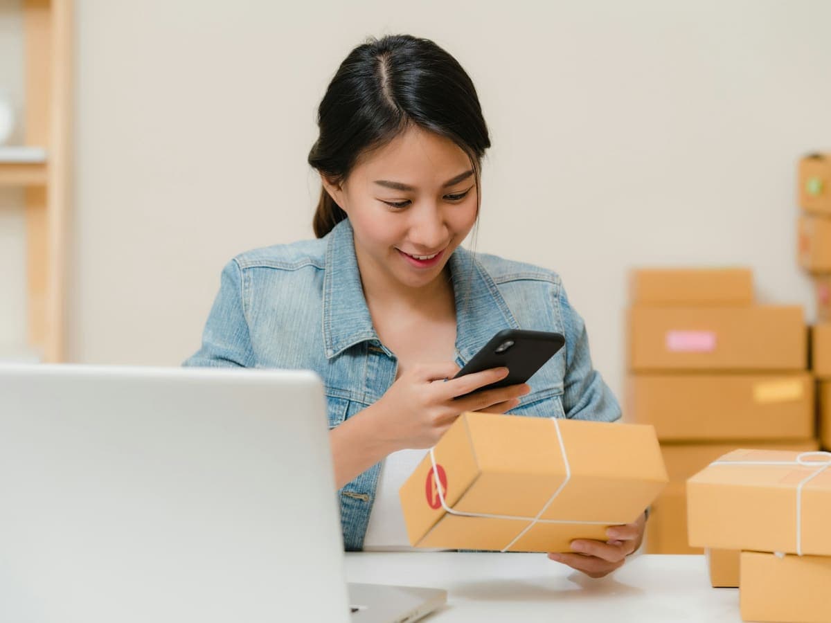 Une commerçante en ligne préparant les commandes de ses clients