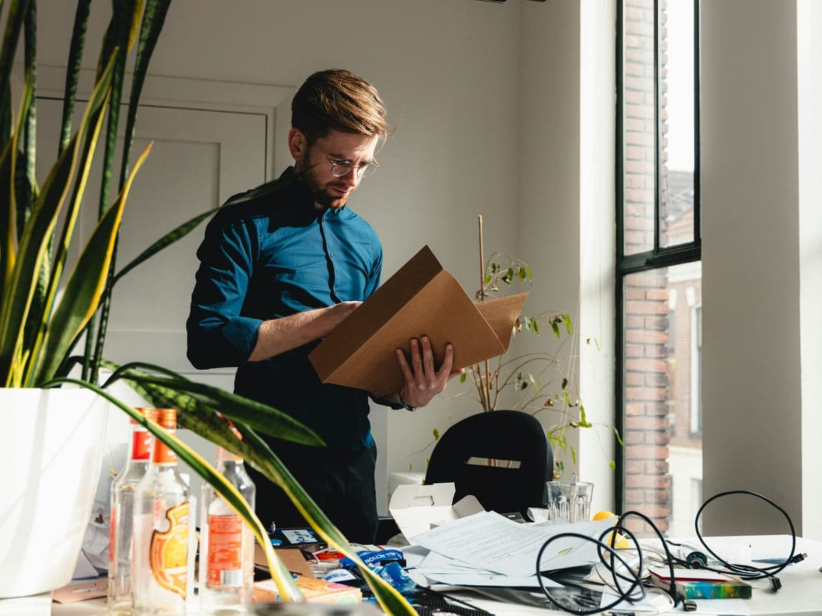 Un collaborateur portant un carton de dossiers dans un bureau